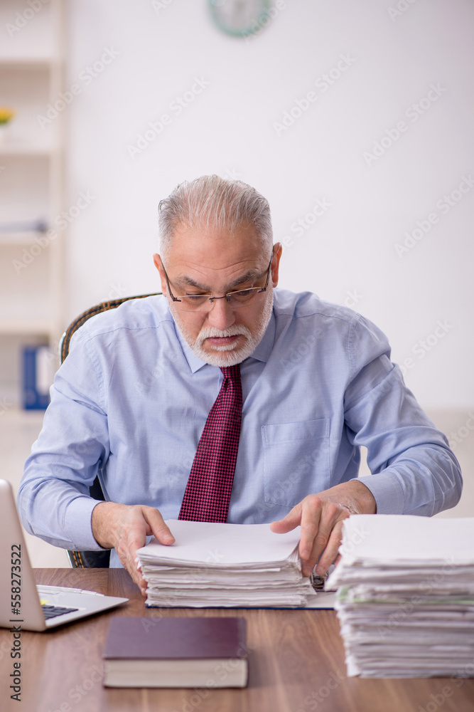 Old male boss working at workplace Old male boss working at workplace