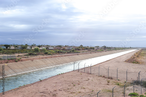 Bilde på lerret A concrete-lined water canal stretching into the distance, bordered by desert te