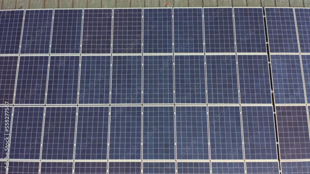Close-up of blue solar panels installed on the roof for renewable energy from the sun aerial view. Solar panels moving shot. modern photovoltaic solar array installed surface of the roof of building. Close-up of blue solar panels installed on the roof for renewable energy from the sun aerial view. Solar panels moving shot. modern photovoltaic solar array installed surface of the roof of building.