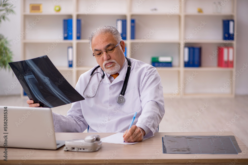 Old male doctor radiologist working in the clinic