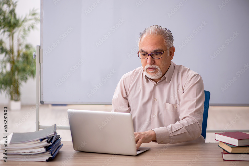 Old male teacher in front of whiteboard Old male teacher in front of whiteboard
