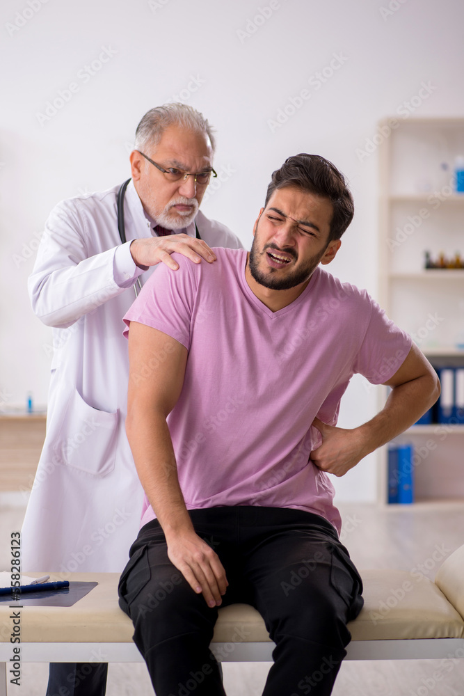 Young male patient visiting old male doctor Young male patient visiting old male doctor