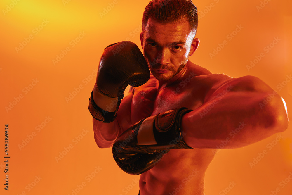 Man bodybuilder boxer muscle workout with naked torso. Advertising, sports, active lifestyle, color light, competition, challenge concept. 