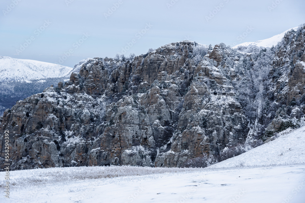 Bizarre rocks of Valley of ghosts in snow on Mount Demerdzhi in spring. Crimea