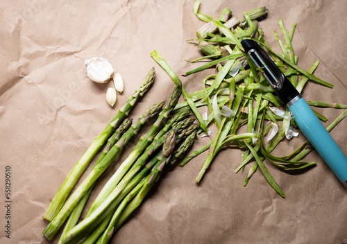 Bunch of green peeled asparagus with garlic  on the table