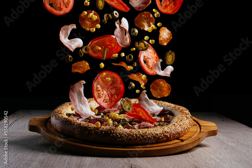 levitating pizza ingredients. pizza on a wooden board