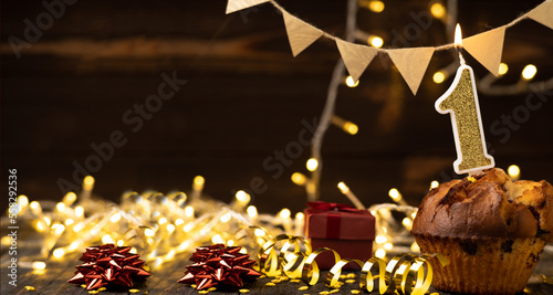 Canvas Print Number 1 gold burning candle in a cupcake against celebration wooden background with lights