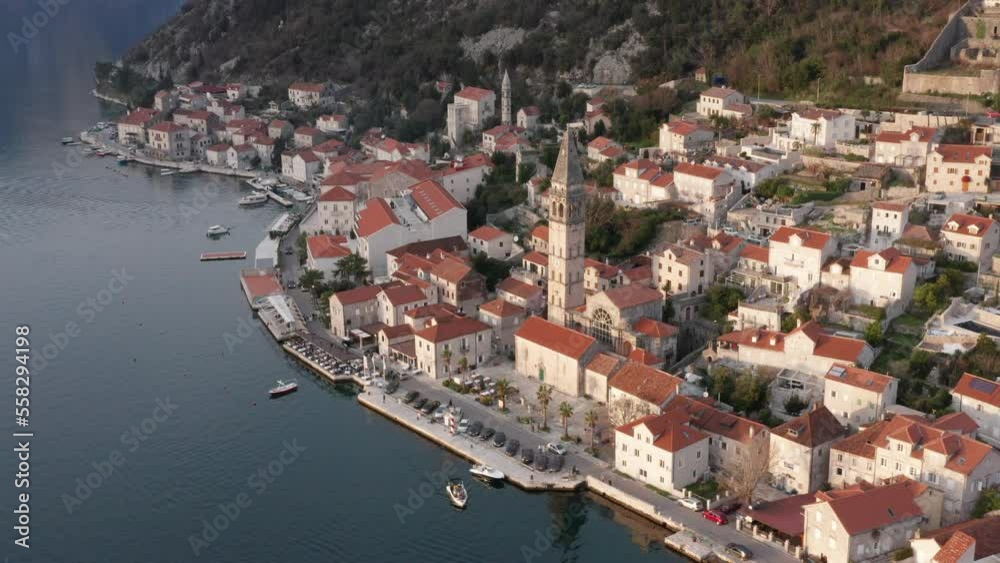 Perast Montenegro - old Mediterranean town on the coast of the Bay of Kotor. Aerial drone view of the waterfront featuring bell tower and surrounded by houses with red roofs. Perast Montenegro - old Mediterranean town on the coast of the Bay of Kotor. Aerial drone view of the waterfront featuring bell tower and surrounded by houses with red roofs.