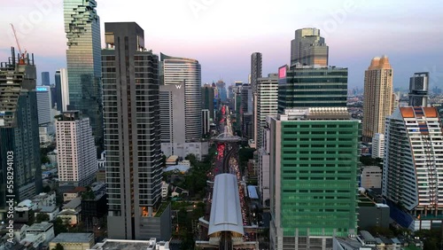 BTS Skytrain tracks and Saint Louis station drives in Thailand's capital. Drone flight in Bangkok with skyscrapers, highways, traffic, cars, and the river. photo