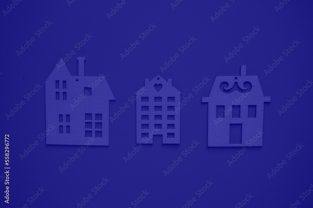 Home and building insurance. A secure future for your home. Flat wooden houses on blue background view from above. Blurred background. 