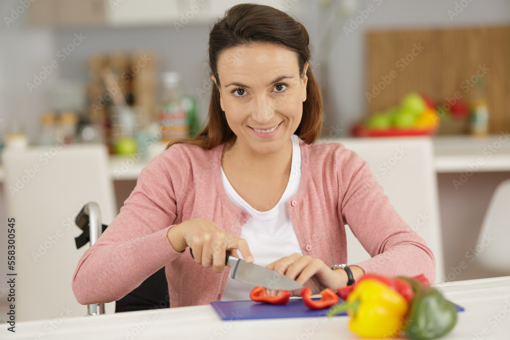 disabled woman in wheelchair preparing meal in kitchen disabled woman in wheelchair preparing meal in kitchen