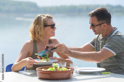 couple eating salad in alfresco restaurant photo