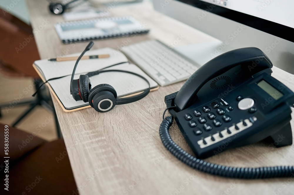 Telemarketing office, phone and VOIP on desk for communication, contact us and consulting by computer. Modern office, telephone and headphones on table for customer support, help or service with pc Telemarketing office, phone and VOIP on desk for communication, contact us and consulting by computer. Modern office, telephone and headphones on table for customer support, help or service with pc