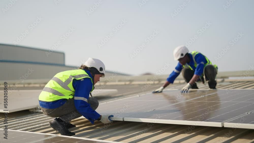 Engineer on rooftop sitting next to solar panels photo voltaic check alignment for good installation Engineer on rooftop sitting next to solar panels photo voltaic check alignment for good installation