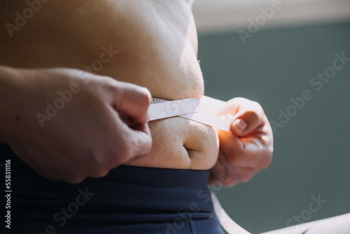 Beautiful fat woman with tape measure She uses her hand to squeeze the excess fat that is isolated on a white background. She wants to lose weight, the concept of surgery and break down fat under the