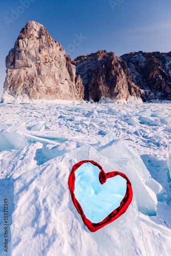 Beautiful winter landscape, Lake Baikal on sunny day with frozen ice with red heart from scarf