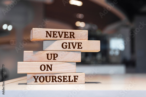 Wooden blocks with words 'Never give up on yourself'.
