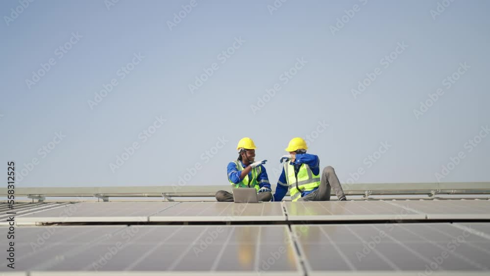 Engineer on rooftop sitting next to solar panels rest sitting relaxation after work completed Engineer on rooftop sitting next to solar panels rest sitting relaxation after work completed