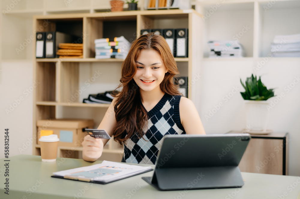 © Nuttapong punna - Woman using smart phone for mobile payments online shopping,omni channel,sitting on table,virtual icons graphics interface screen in morning light.