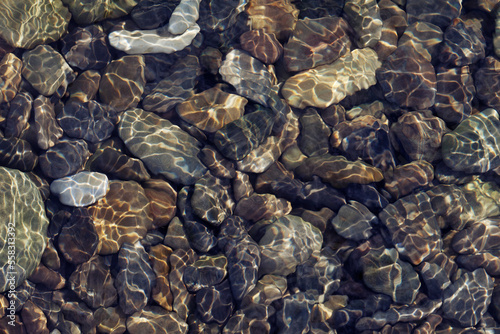 Obraz na płótnie Ripple patterns reflect light on shallow flowing clear water over pebbles w salonie