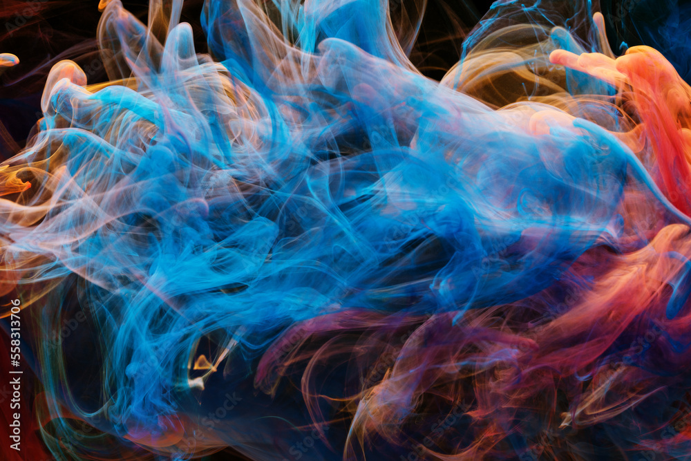 A mixture of colorful ink swirls in water on a black background. Abstract concept photo