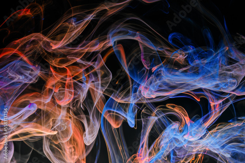 Obraz na płótnie A mixture of colorful ink swirls in water on a black background. Abstract concept photo w salonie