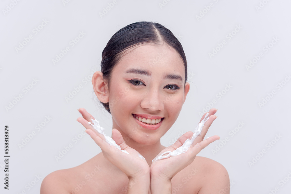Beautiful Asian woman smiling for the camera with facial soap foam on her hands. Studio shot isolated on a white backdrop. Beautiful Asian woman smiling for the camera with facial soap foam on her hands. Studio shot isolated on a white backdrop.
