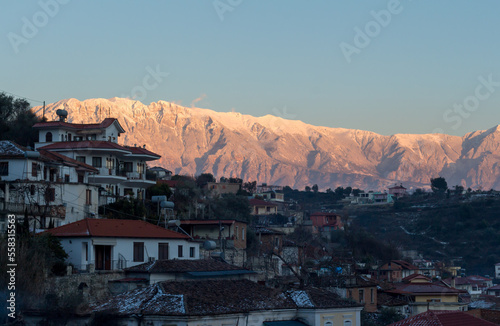 Beautiful panorama of Berat by sunset in winter, with mountains covered with snow in the background, Albania.