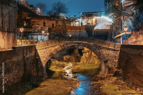 Tbilisi, Georgia, Night Scenic View Of old Bridge of Love in Bath District - Is The Ancient District Of Tbilisi, Georgia. Hanging houses above rvier in canyon. Leghvtakhevi Canyon