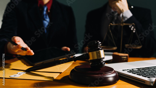 Business and lawyers discussing contract papers with brass scale on desk in office. Law, legal services, advice, justice and law concept picture with film grain effect © ARMMY PICCA