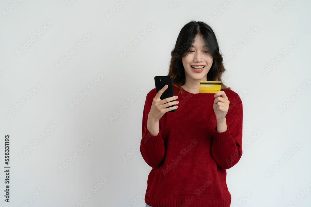 Asian woman holding smartphone and credit card on white background, name concept of online and paying Asian woman holding smartphone and credit card on white background, name concept of online and paying