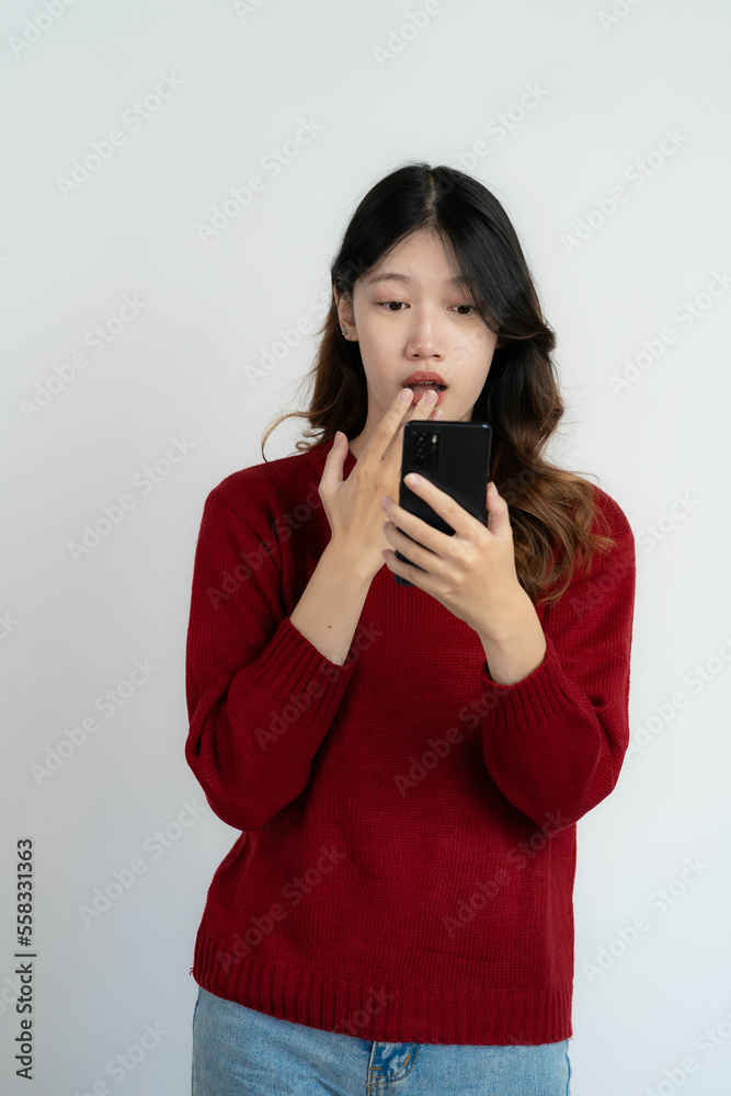 Asian long haired black woman holding smartphone feeling very happy Excited and surprised hand gestures Studio portrait isolated on white background