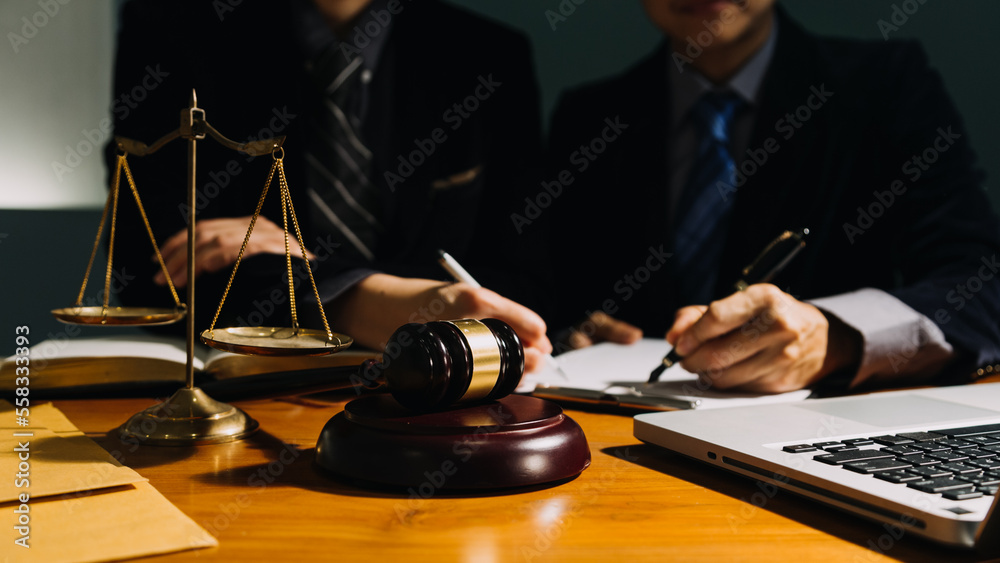 Business and lawyers discussing contract papers with brass scale on desk in office. Law, legal services, advice, justice and law concept picture with film grain effect Business and lawyers discussing contract papers with brass scale on desk in office. Law, legal services, advice, justice and law concept picture with film grain effect