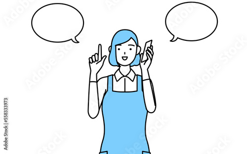 電話をしながら指さしをするエプロンを着た女性