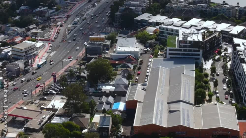 Aerial shot of Australianbusy suburb by bridge with river heavy traffic on roads with cars and businesses Aerial shot of Australianbusy suburb by bridge with river heavy traffic on roads with cars and businesses