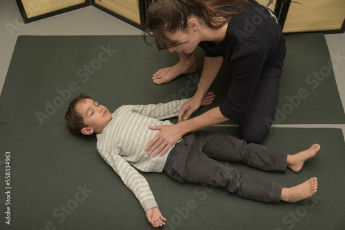 Caucasian osteopath performing stretches with a young boy photo