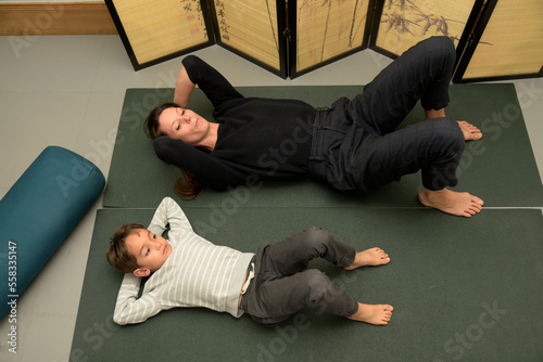 Caucasian osteopath performing stretches with a young boy