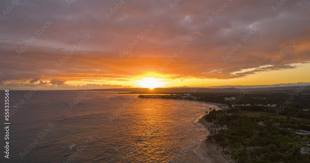 Sur rising over the clouds in the coast with a stunning warm beach in the caribbean, stunning sunrise