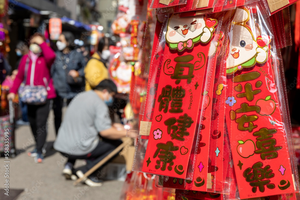 Obraz premium 2023 Jan 4,Hong Kong.Street stalls in Mong Kok sell Chinese New Year gifts and write congratulatory words on red paper,Call it Fai chun