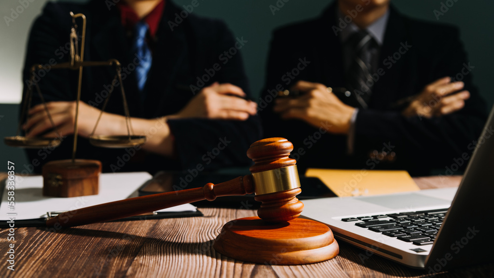 Business and lawyers discussing contract papers with brass scale on desk in office. Law, legal services, advice, justice and law concept picture with film grain effect Business and lawyers discussing contract papers with brass scale on desk in office. Law, legal services, advice, justice and law concept picture with film grain effect
