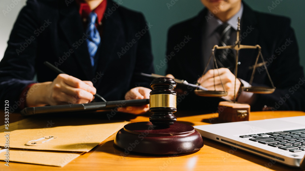 Business and lawyers discussing contract papers with brass scale on desk in office. Law, legal services, advice, justice and law concept picture with film grain effect Business and lawyers discussing contract papers with brass scale on desk in office. Law, legal services, advice, justice and law concept picture with film grain effect