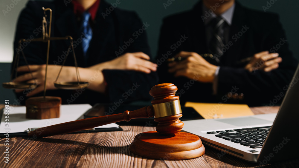 Business and lawyers discussing contract papers with brass scale on desk in office. Law, legal services, advice, justice and law concept picture with film grain effect Business and lawyers discussing contract papers with brass scale on desk in office. Law, legal services, advice, justice and law concept picture with film grain effect