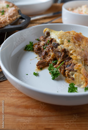 Steak and cheese pie on a plate. Cooked in a cast iron pan with beef shanks