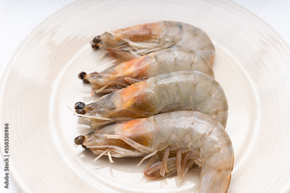 Fresh raw shrimp plated in a bowl on white background Fresh raw shrimp plated in a bowl on white background
