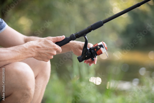 man holds fly rod with one hand