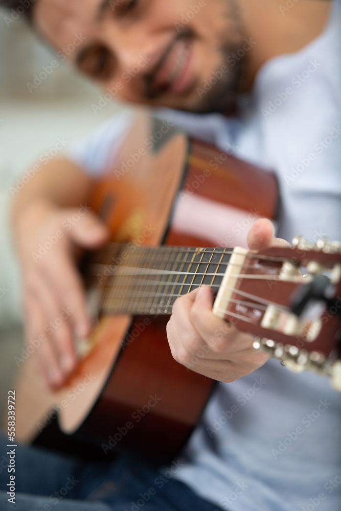 close up of man playing acoustic guitar