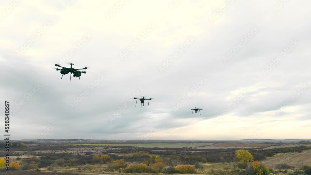 Combat military drones fly on the sky background.