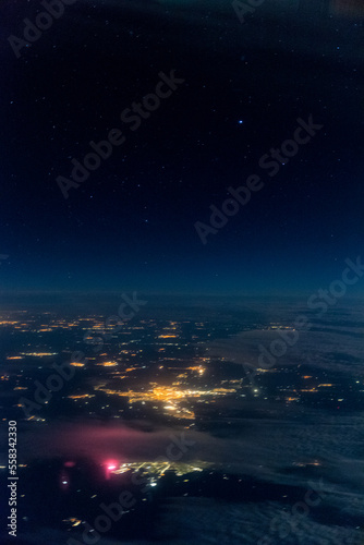 Stars and iluminated city from plane at night