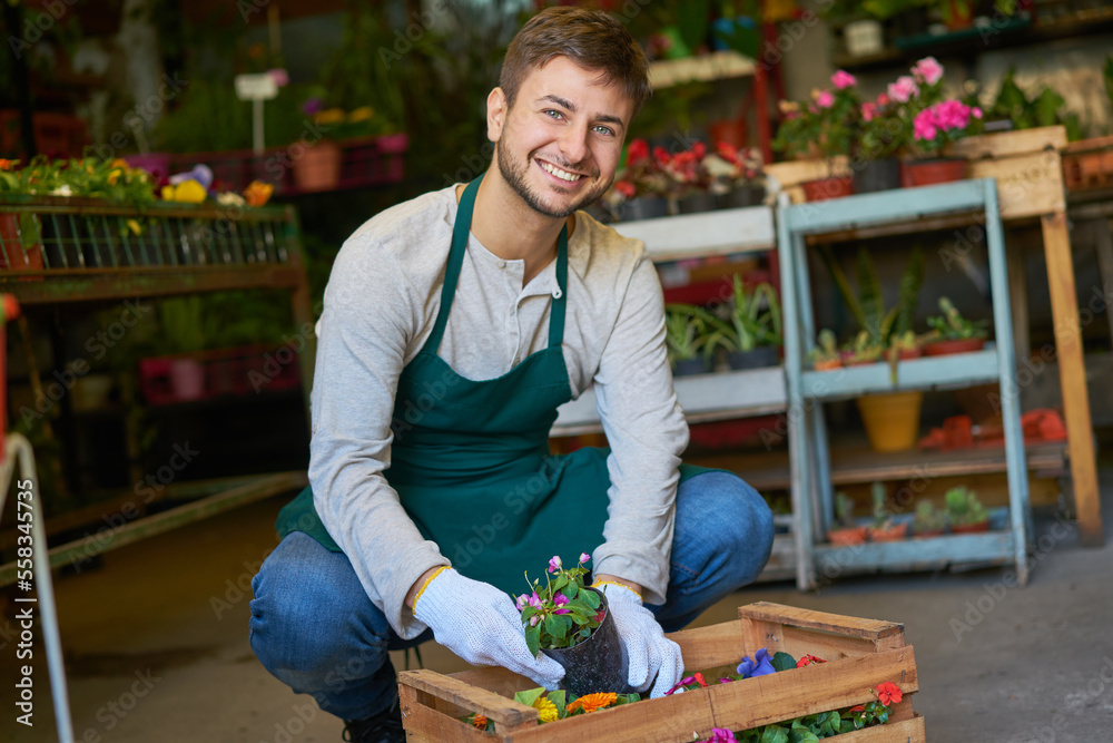 Gärtner Lehrling mit einer Kiste Blumen für eine Lieferung Stock Photo