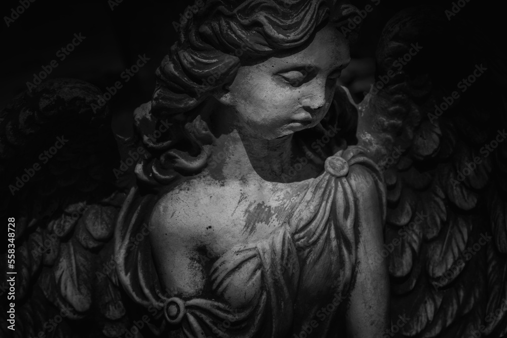 Black and white image of angel of death. Ancient destroyed statue. Fragment.
